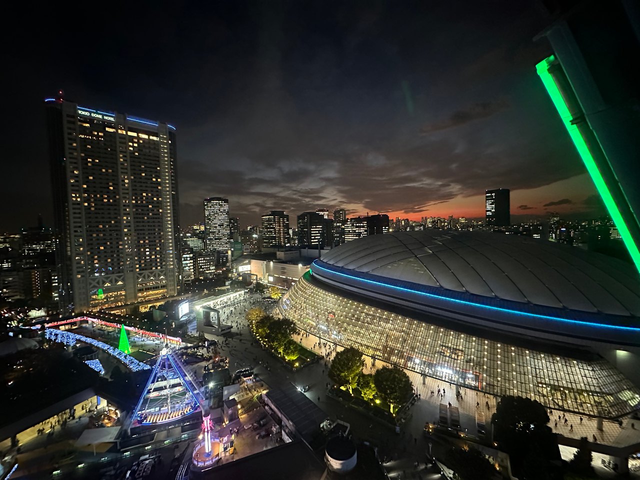 An elevated night view of a large domed arena and illuminated surrounding streets